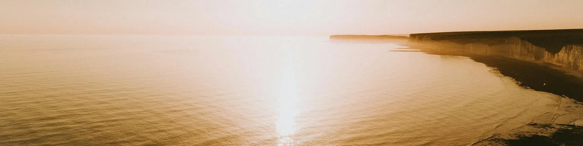 Peaceful golden sunset over a calm coastline
